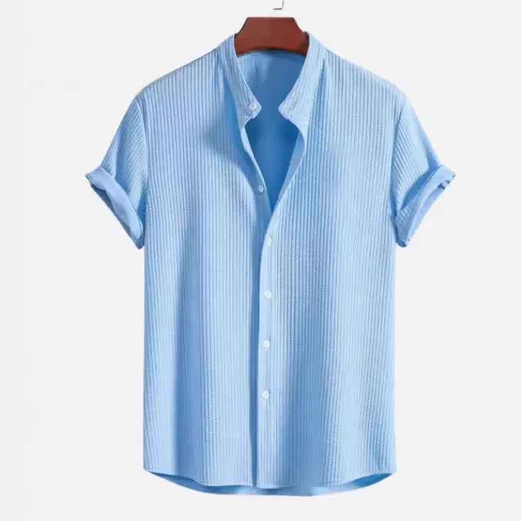 Man wearing a loose-fitting short sleeve casual shirt in a light blue colour.