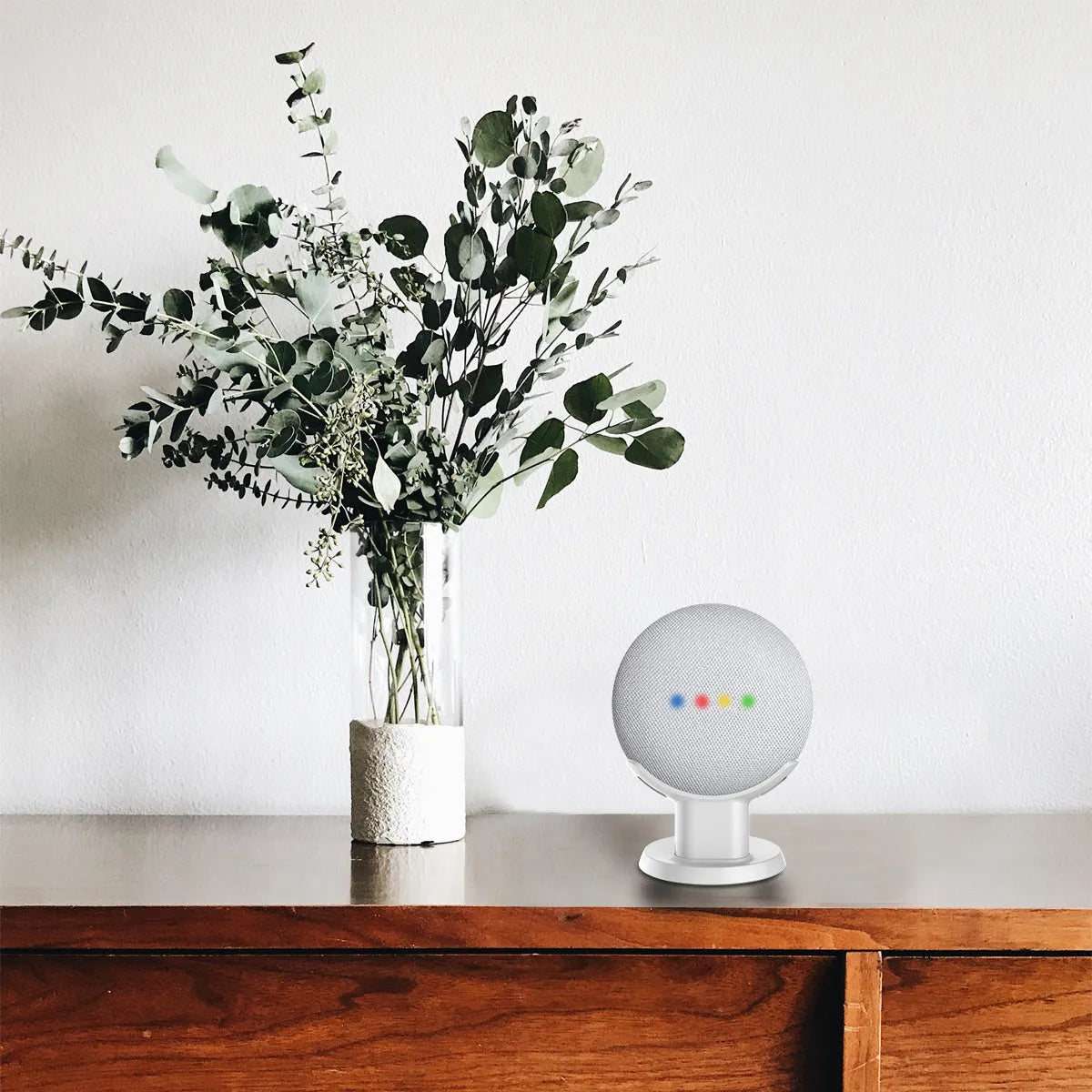 Black Google Home Mini plastic stand on a wooden desk