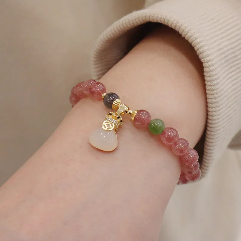 Natural strawberry quartz women's bracelet with geometric design, peace buckle closure, and lucky bagg purse charm attachment