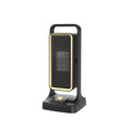 Black compact PTC ceramic desktop air heater with control knob on a wooden desk.