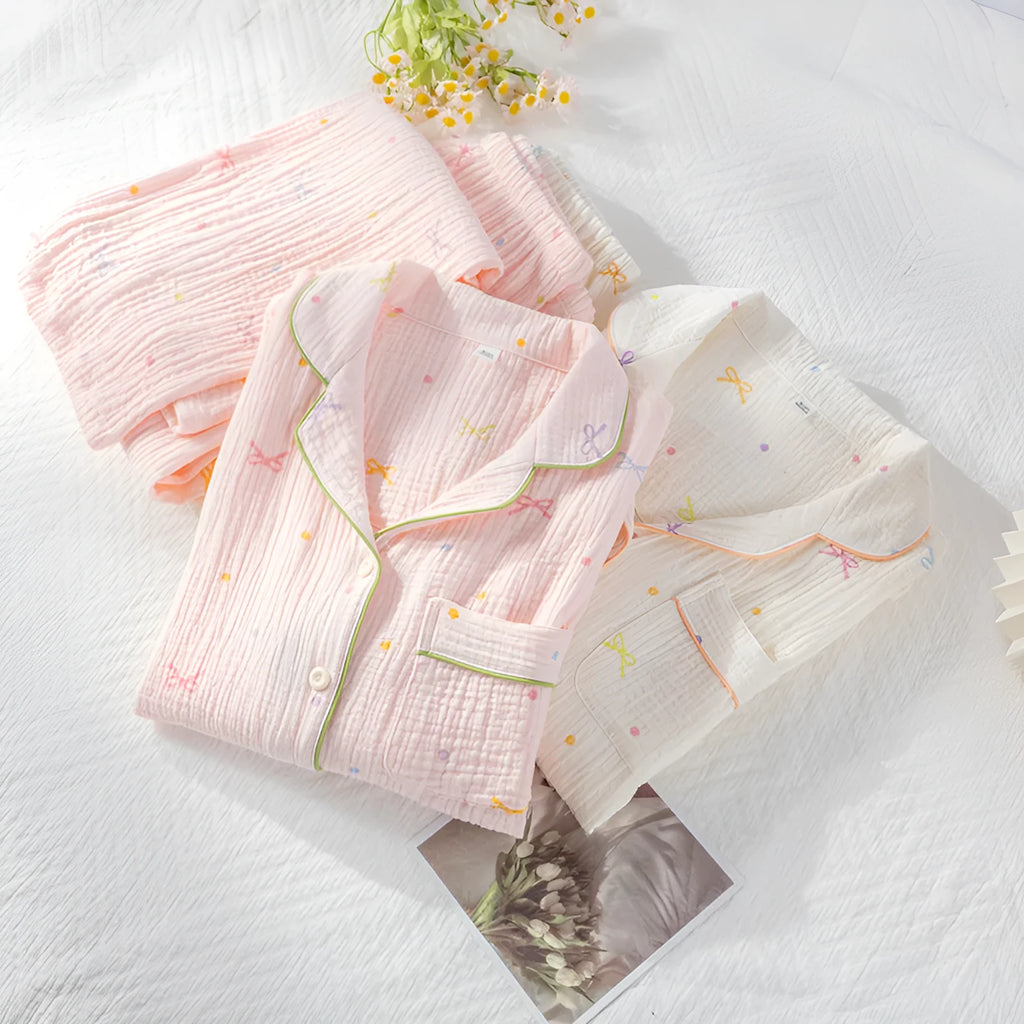 Women's cotton pajama set with long sleeves in pink colour showing top and trousers laid flat