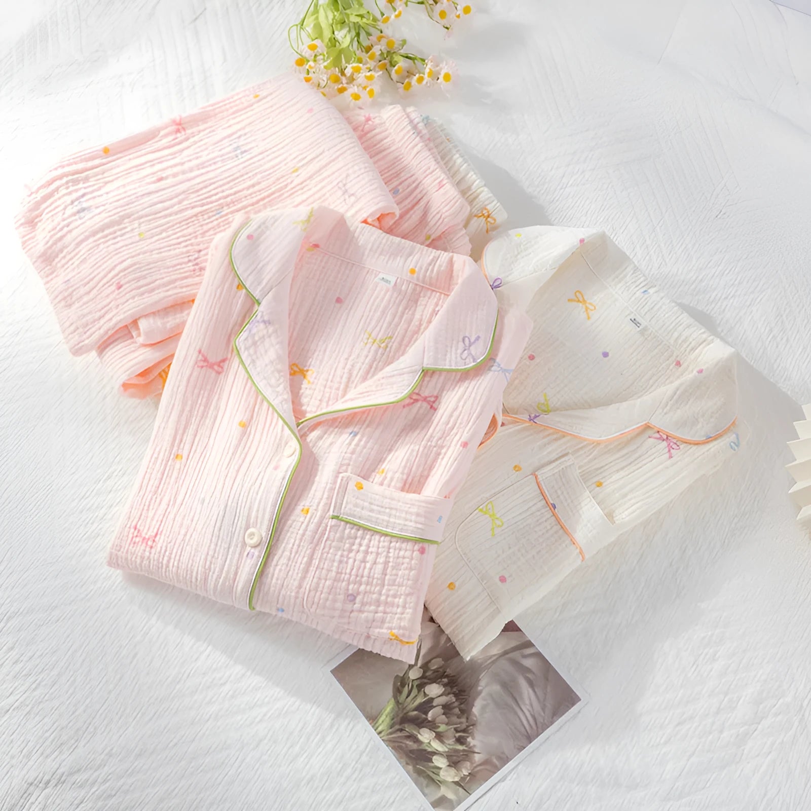 Women's cotton pajama set with long sleeves in pink colour showing top and trousers laid flat