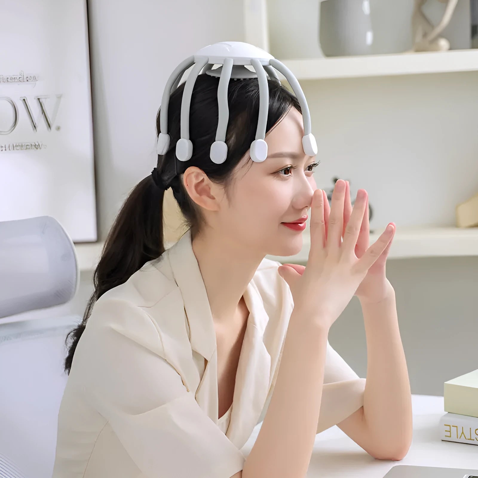Black eight-claw electric head massager with USB cable on white background.