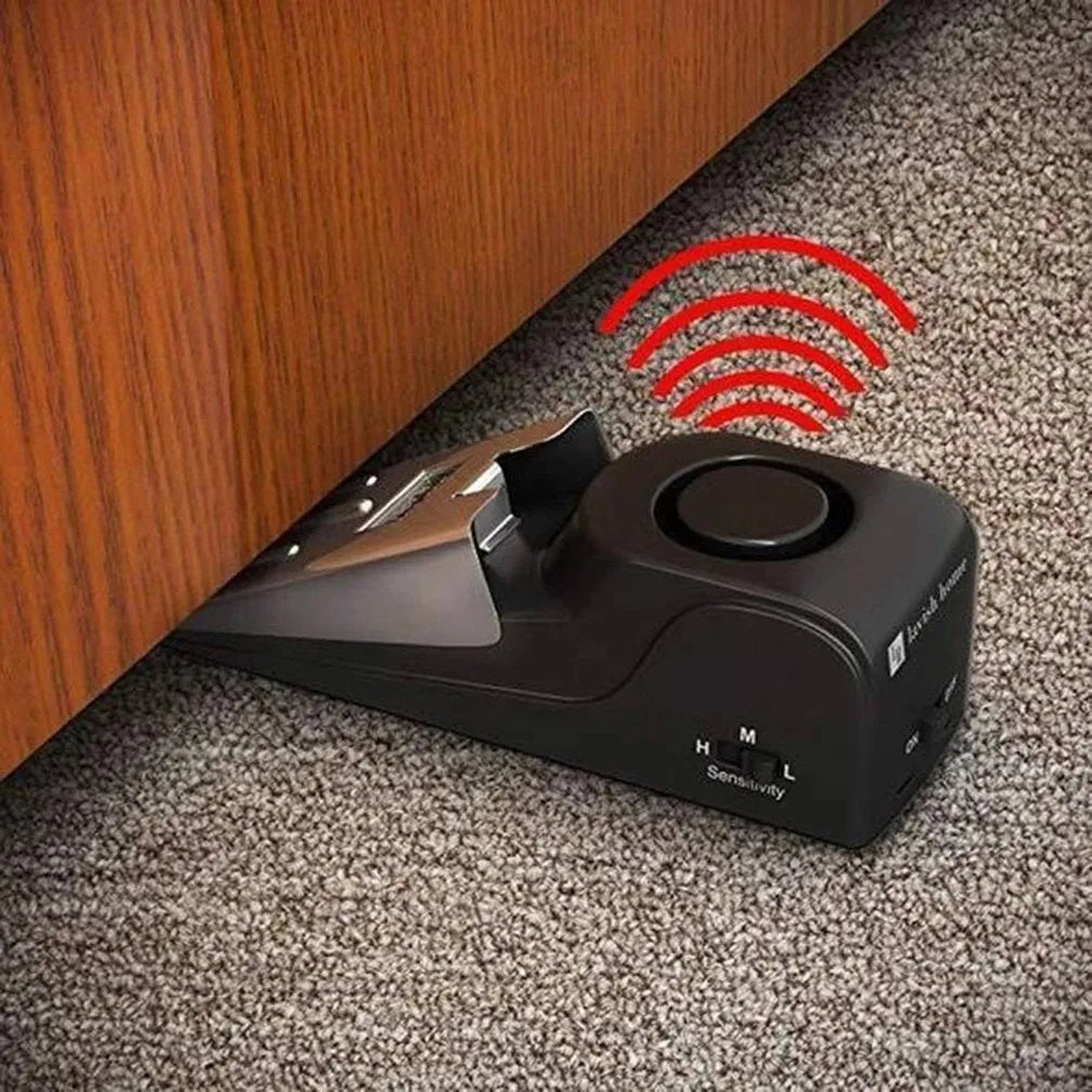 Black portable wedge-shaped door stop alarm with a stainless steel cover for home and travel security.
