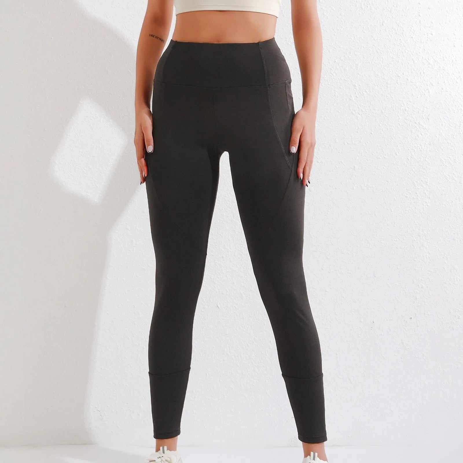 Black cropped leggings with high waist and zipper pocket on a model