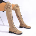 Black lace-up over the knee boots with a round toe and flat rubber sole on a plain background.