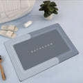 Oval natural rubber bathroom floor mat in blue on tiled floor