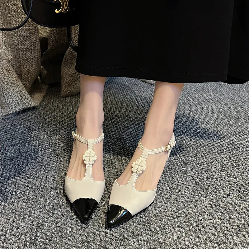 Women's black pointed toe stiletto shoe with flower buckle detail on a 3-5cm heel.