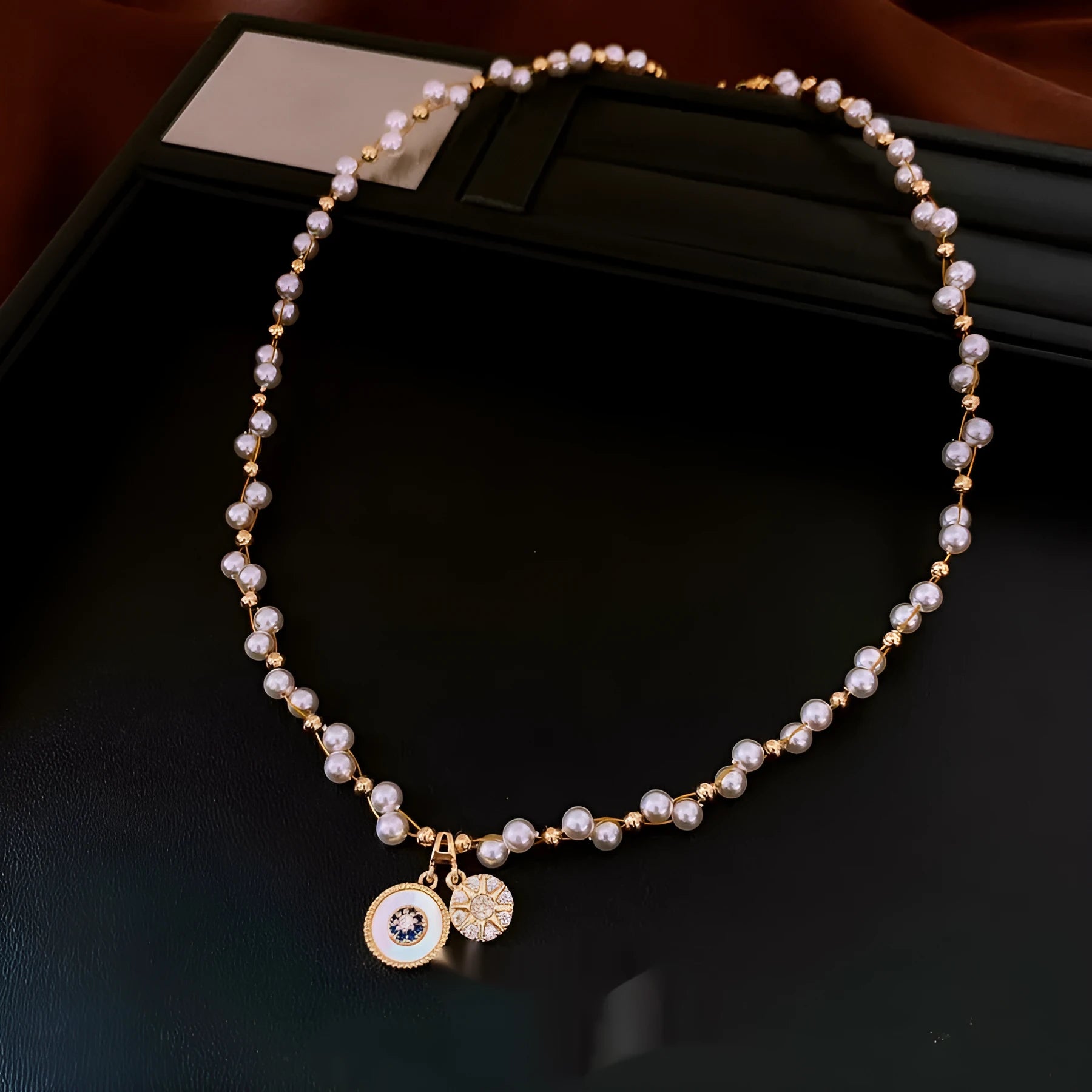Gold electroplated necklace with round imitation pearl pendant featuring zircon details on adjustable clavicle chain
