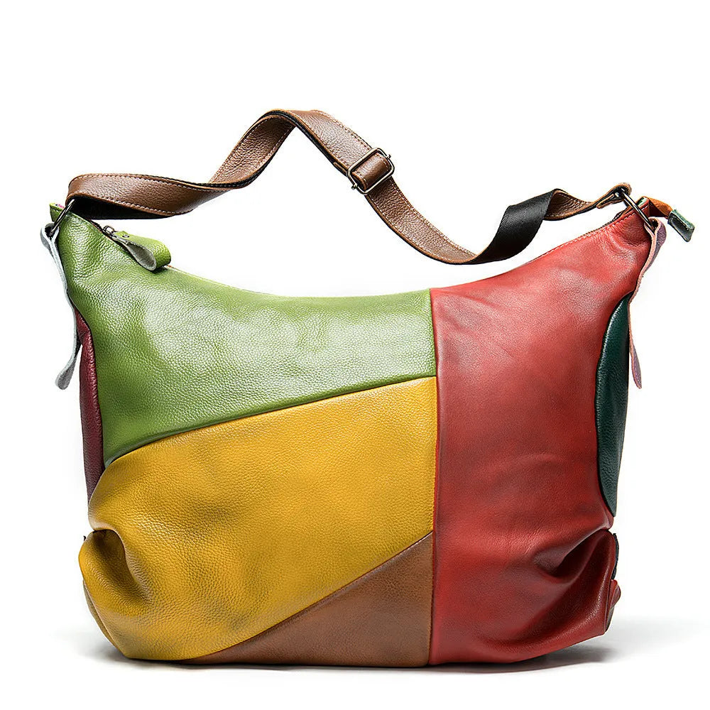 Brown cowhide leather travel bag with stitching, shown as a crossbody bag with a laptop and iPad inside.