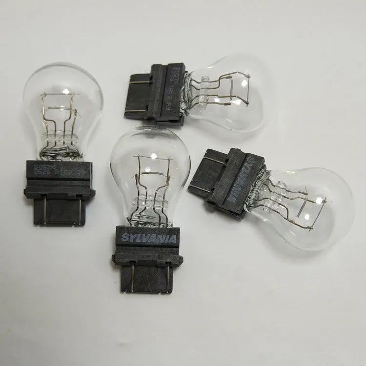 Wagner dual-wire brake light bulb with yellow glass and plastic orientation dot.