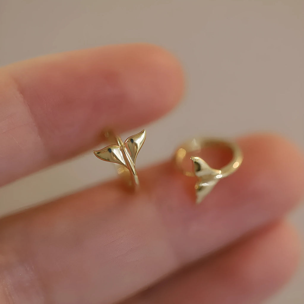 A pair of smooth sterling silver fishtail hoop earrings with a gold plated finish.