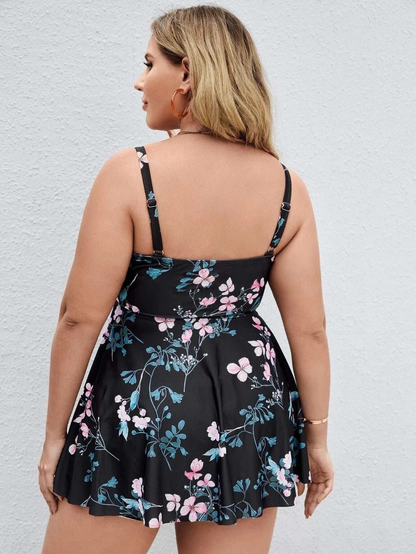 Women's floral print one-piece swimsuit with split colour design, shown on a hanger.