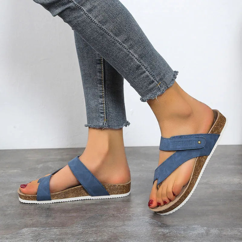 Blue thick-soled flip-flops with a flat toe ring on a light background