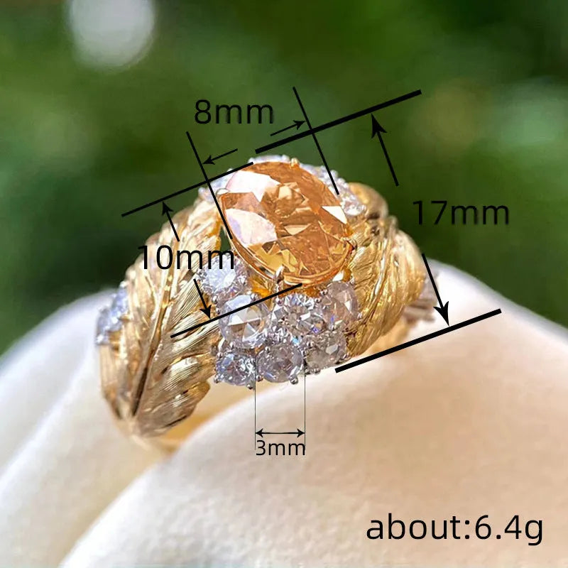 Gold-coloured copper ring with embossed feather design and inlaid yellow zircon stones.