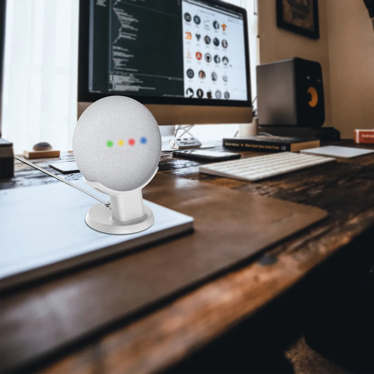 Black Google Home Mini plastic stand on a wooden desk