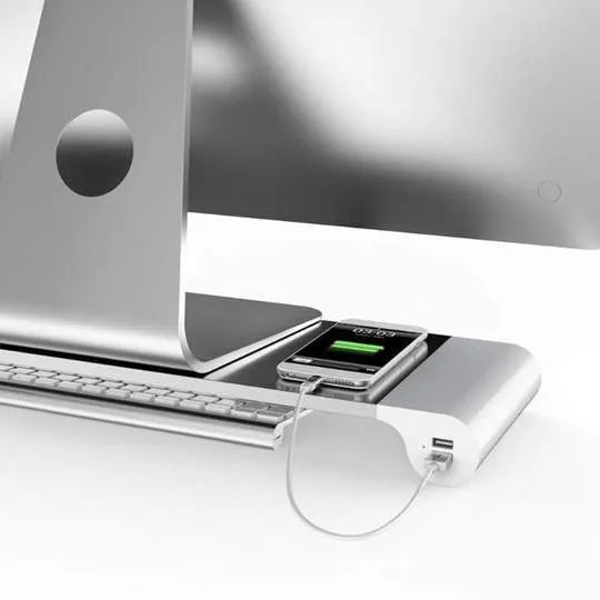 Silver and black computer monitor stand with USB charging ports and hidden keyboard storage compartment