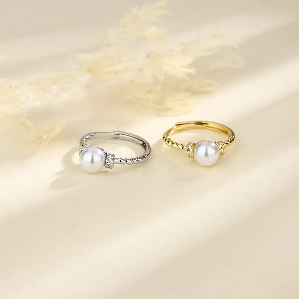 Adjustable antique twist copper ring with a central pearl inlay, shown in gold and silver tone finishes.