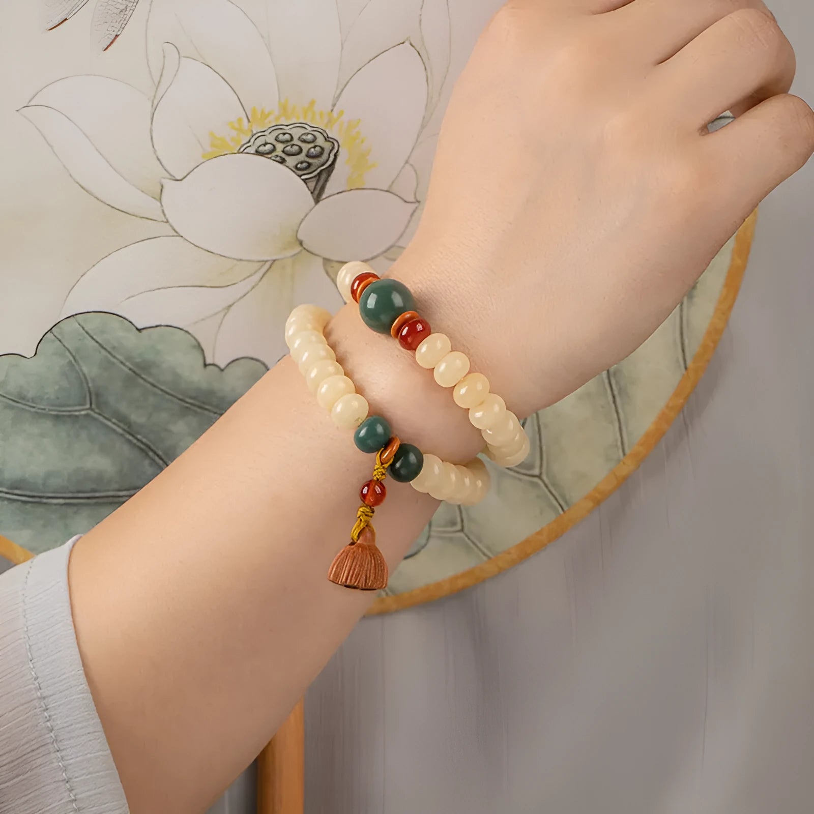 Cream Topaz Bodhi wooden bracelet with flat round beads on a wrist.