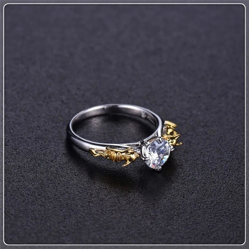 Copper crown design crystal ring in black gold finish on a size chart.