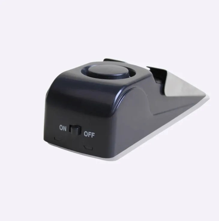 Black portable wedge-shaped door stop alarm with a stainless steel cover for home and travel security.
