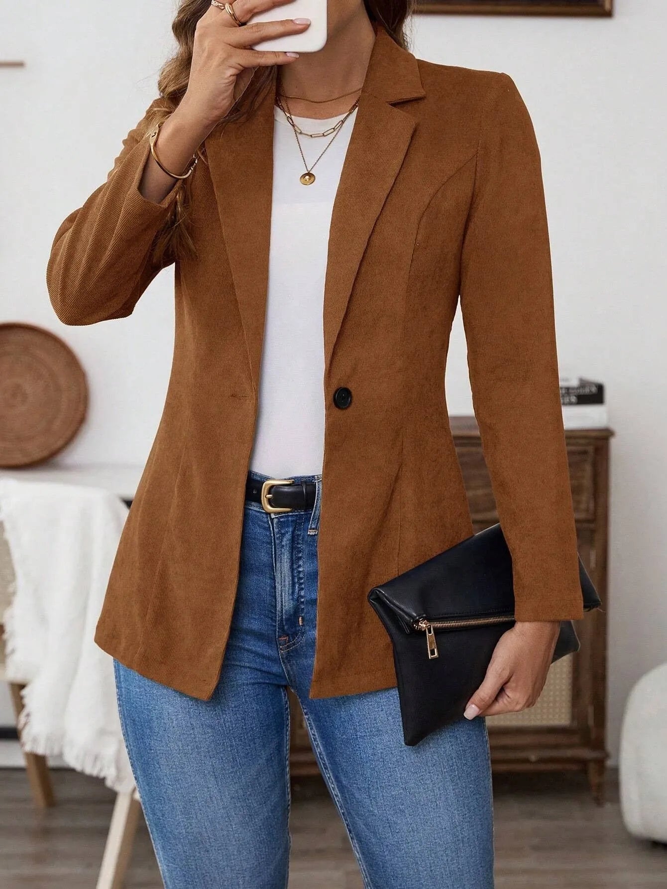 Brown long sleeve single-breasted suit coat with lapel collar on a hanger.