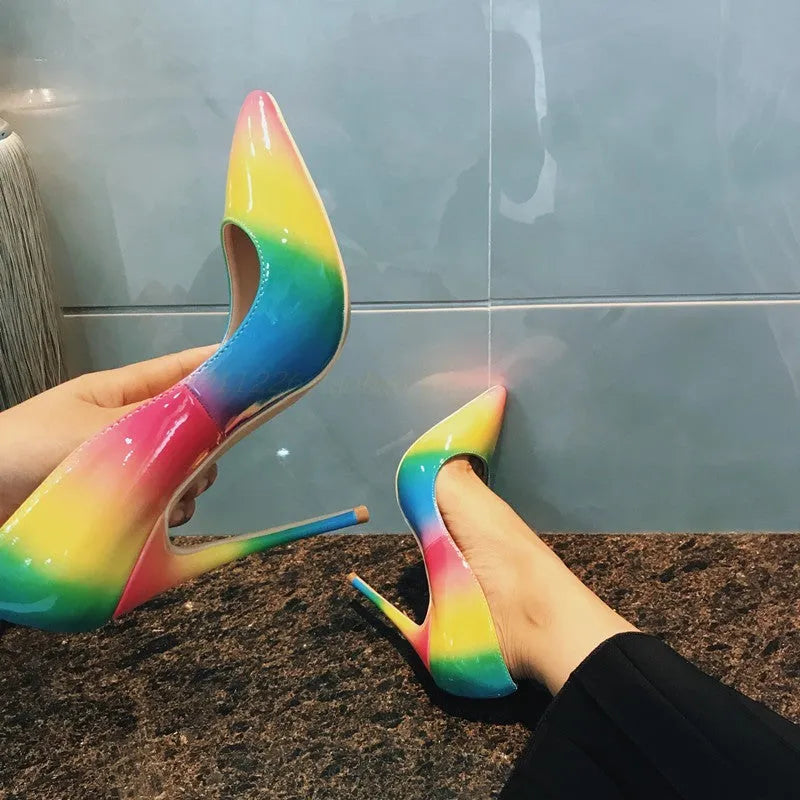 Rainbow coloured patent leather women's court shoes with a pointed toe and a thin ultra-high stiletto heel.
