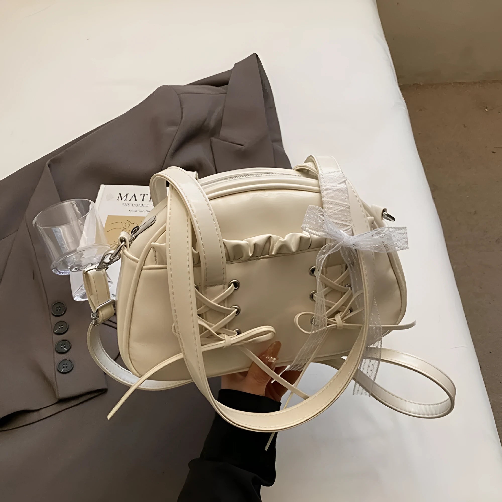 PU leather ladies shoulder bag with bandage bow design and decorative sewing thread in milky white colour