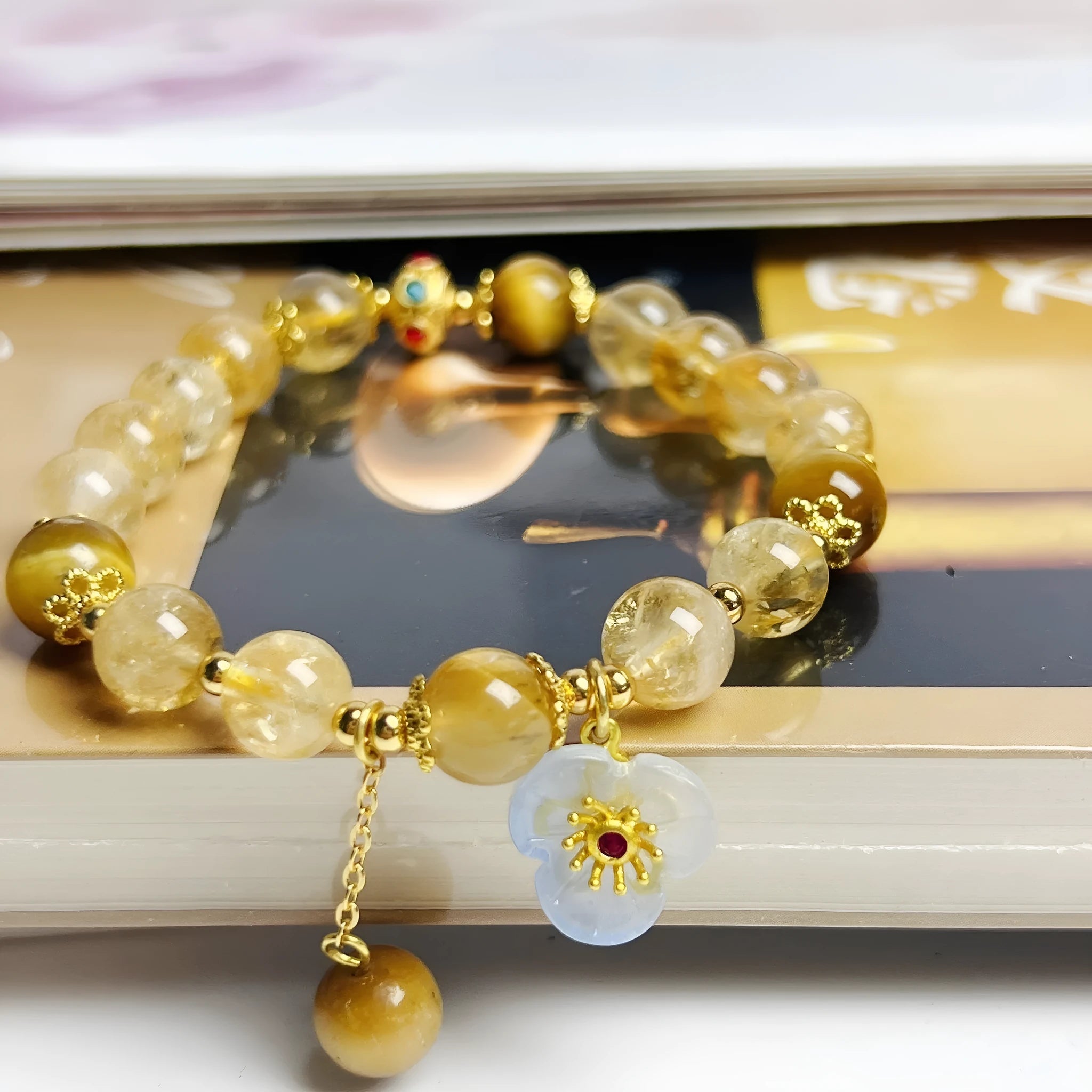Golden yellow citrine crystal bracelet with flower and tassel detail for women.