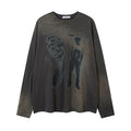A woman wearing a dark grey loose cotton pullover top with drop-shoulder long sleeves.