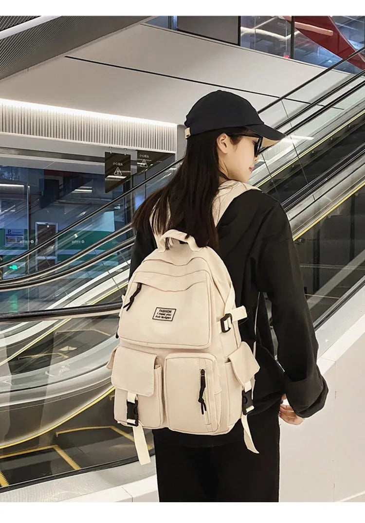 Black and white nylon student backpack with front pockets and laptop compartment.
