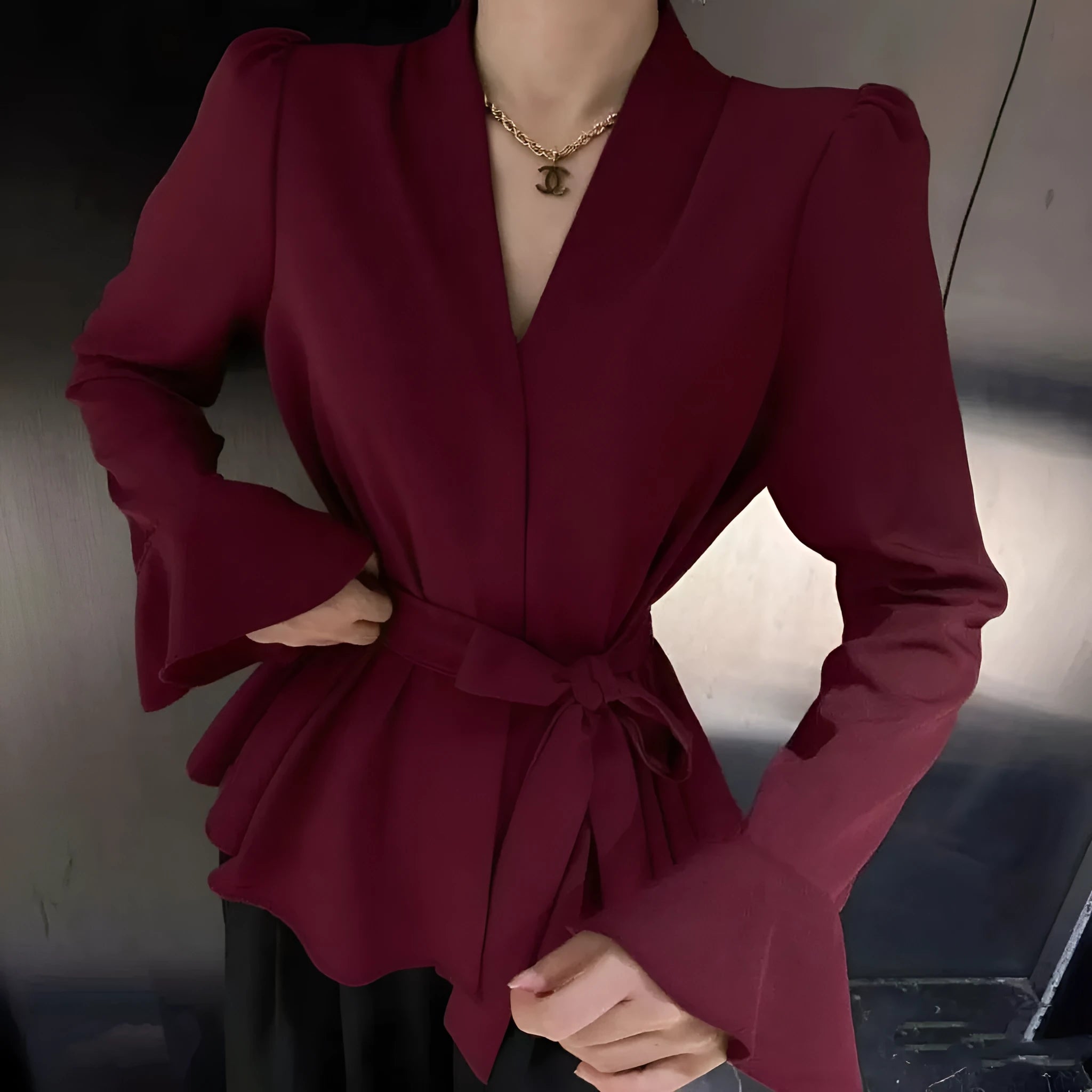 Women's black French-style shirt with irregular collar, tied front, and long flared bell sleeves