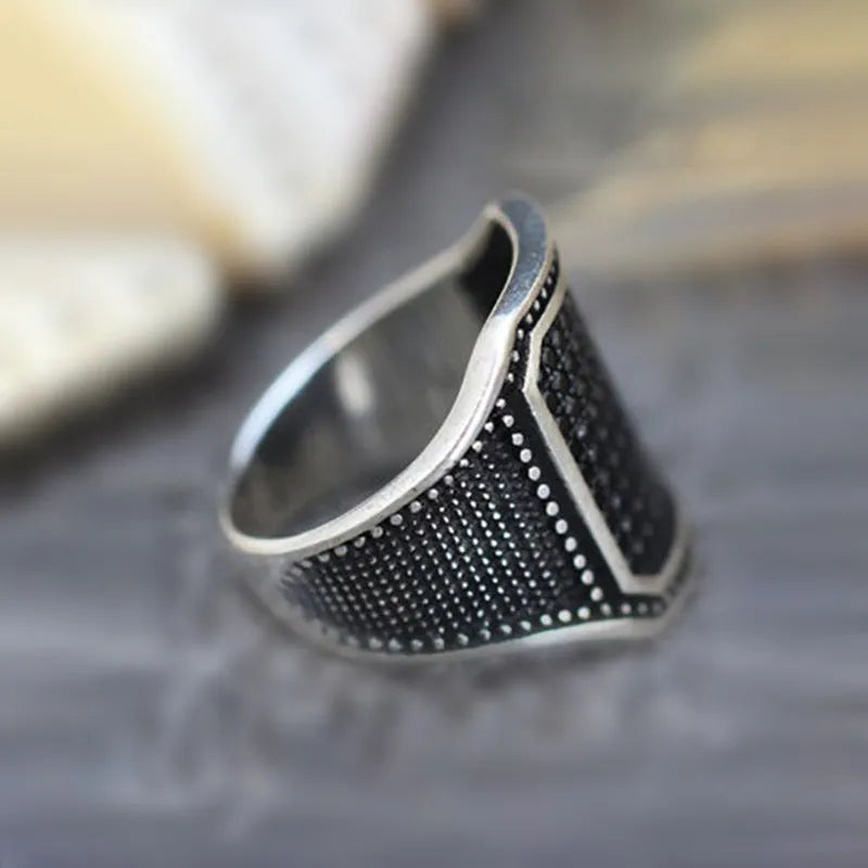 Black alloy ring with copper inlay detail and a single cubic zirconia stone.