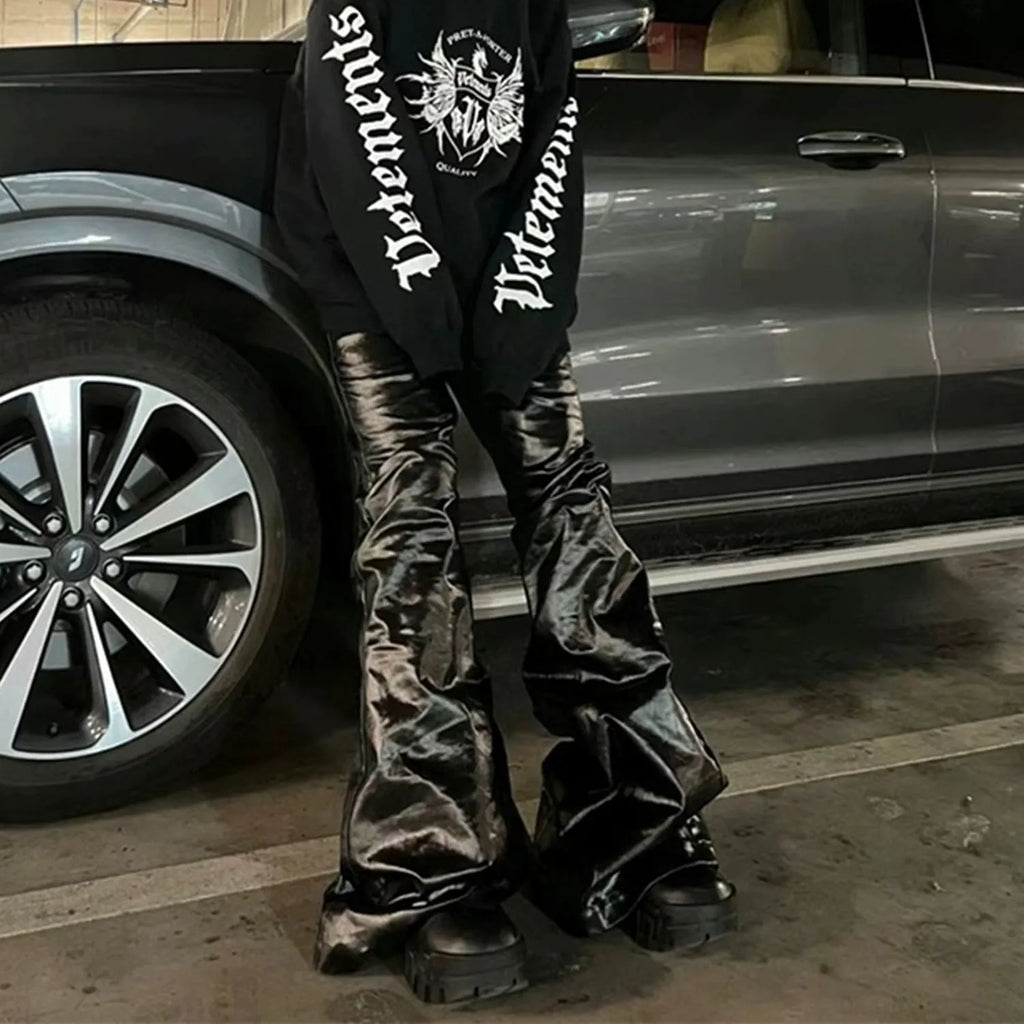 Black coated patent leather skinny jeans with a straight leg and mid-waist fit on a model.