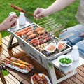 Small foldable portable charcoal grill for outdoor cooking.