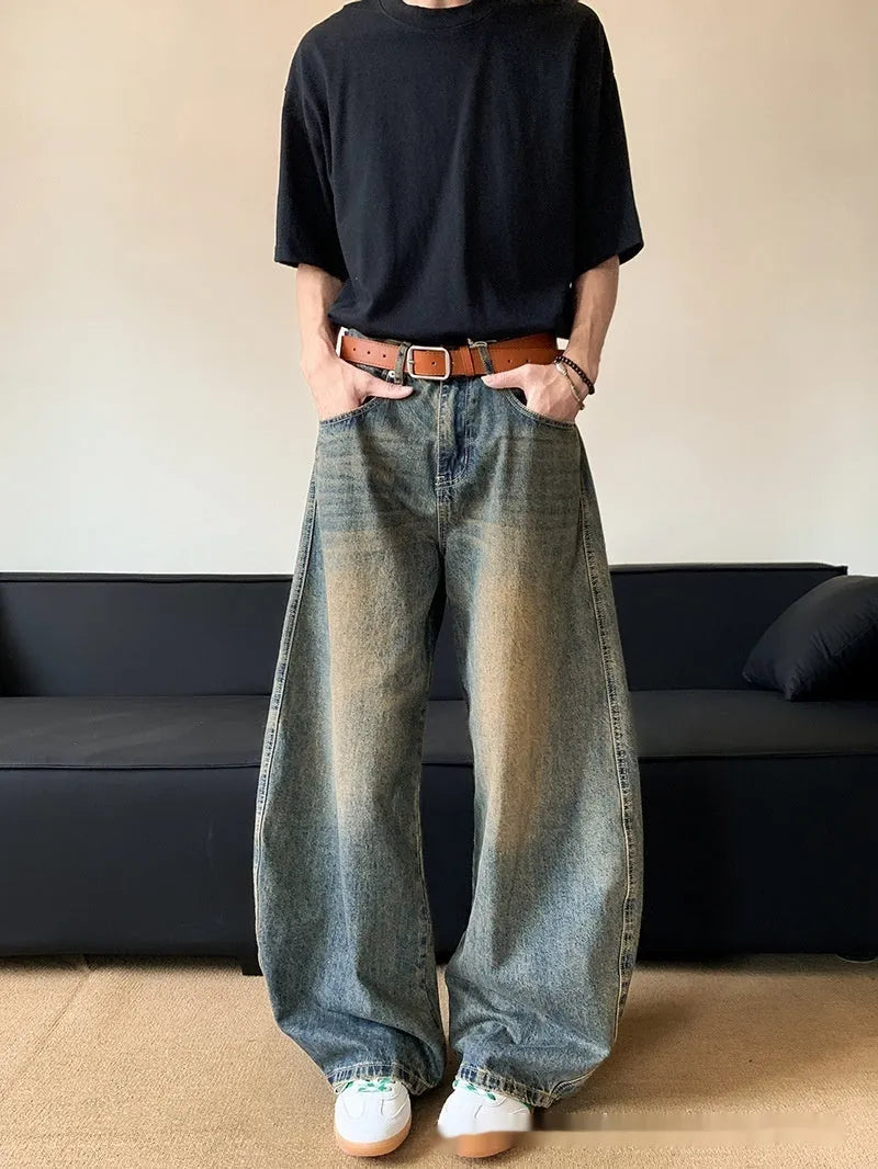 Retro blue men's distressed wide-leg jeans on a neutral background, showing machete detailing and mid-waist zip fly.