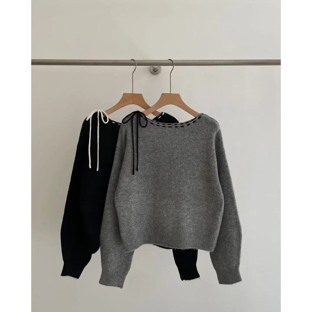Women's loose-fitting black and grey knitwear pullover sweater on a hanger