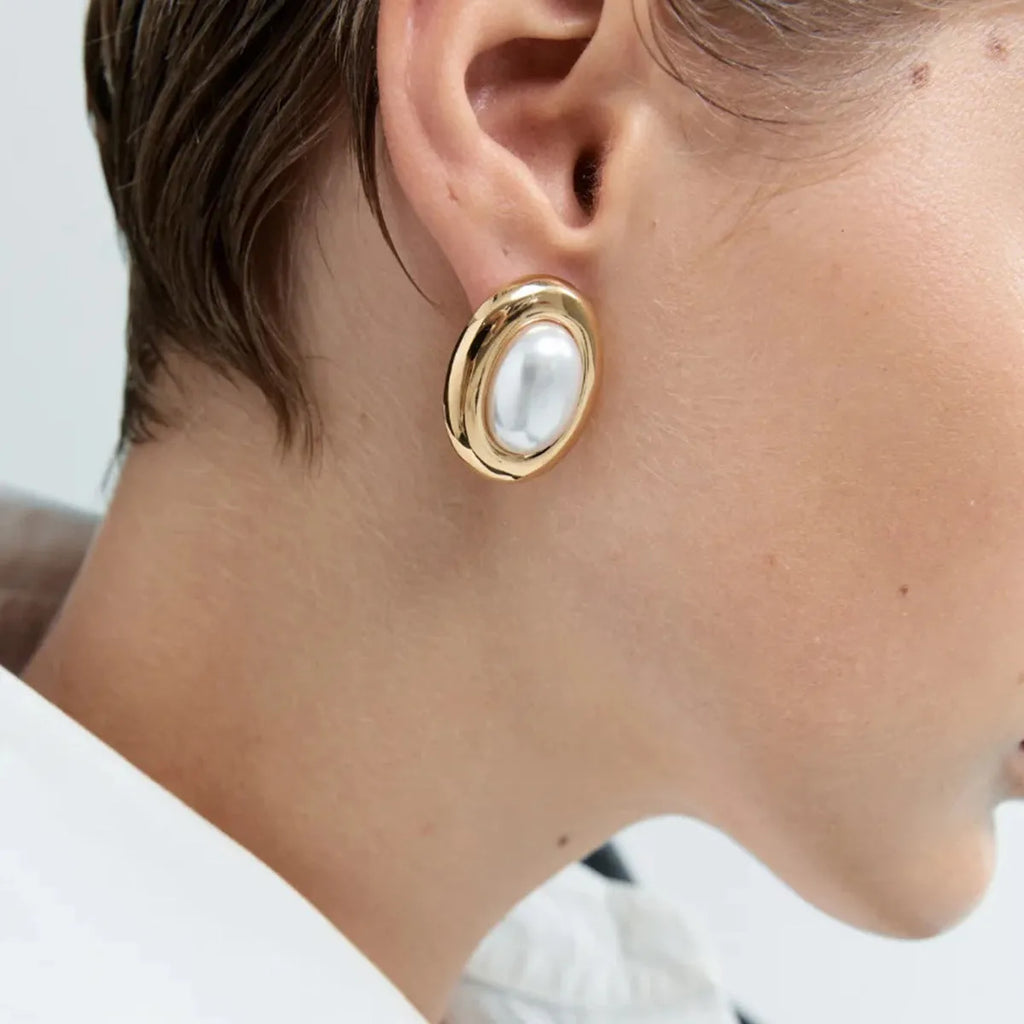 A pair of stainless steel vintage pearl stud earrings with a silver-tone electroplated finish.
