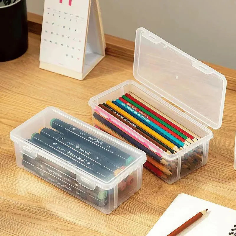 Transparent plastic stationery storage box containing colour pencils and drawing supplies