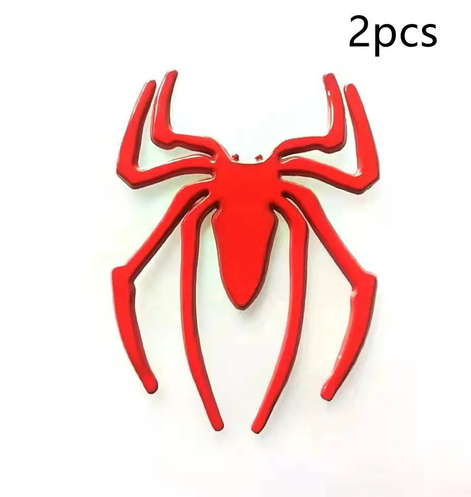 Three-dimensional metal spider bumper sticker in zinc alloy, shown in gold colour, measuring 7 by 5 cm.