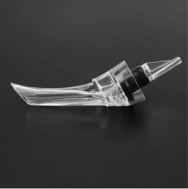 Clear acrylic wine aerator with stainless steel filter, shown next to a wine glass.