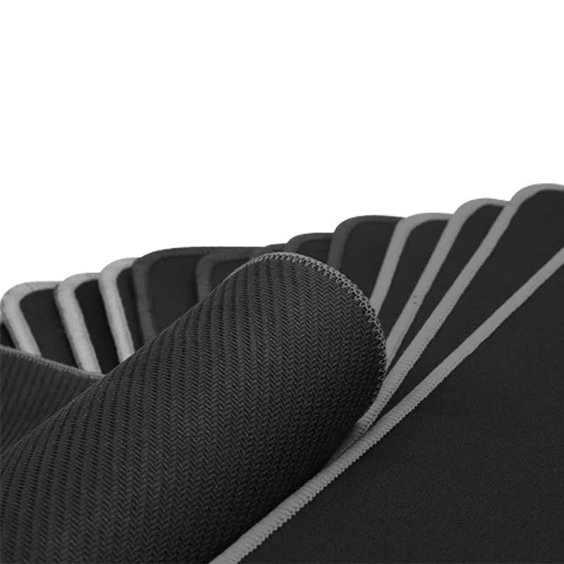 All black extra long desk pad showing overlock stitched edges on a wooden desk.