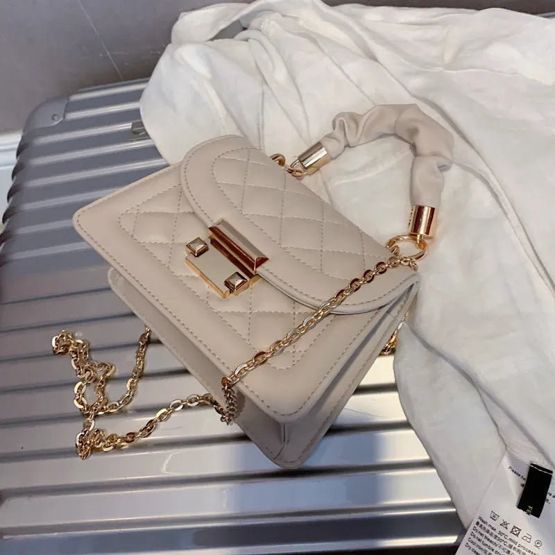 Purple rhombus-shaped women's shoulder bag with a chain strap on a white background.