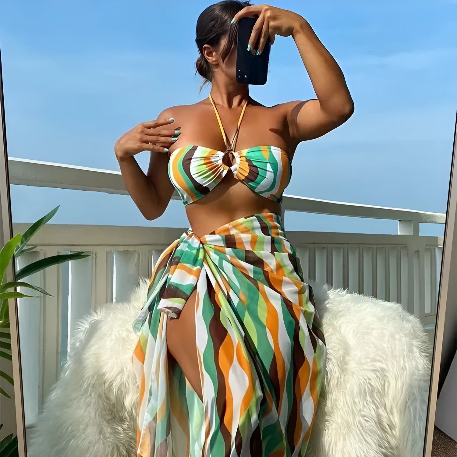 Women's three-piece bikini set with swimsuit top, briefs, and matching printed beach skirt in polyester fabric