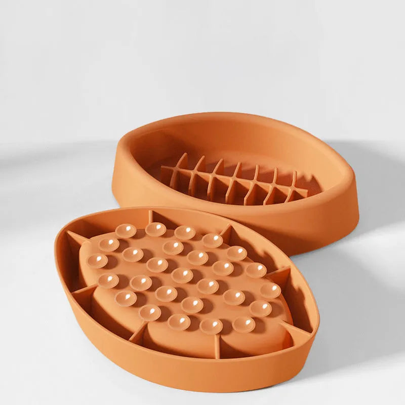 Blue silicone slow feeder pet bowl with ridges and a suction cup base on a floor.