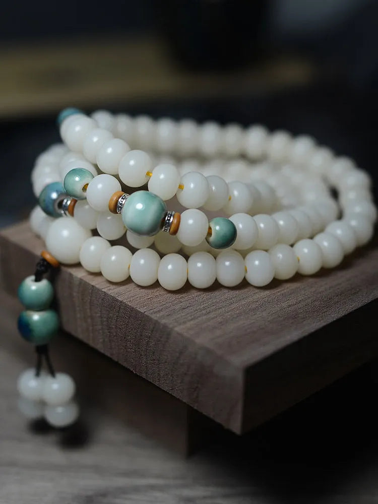 White jade and bodhi seed beaded bracelet with 108 flat round beads in four sizes.
