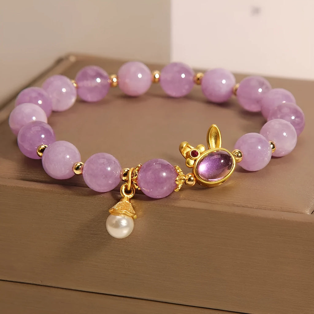 Purplish red mauve jade rabbit head charm on a crystal adjustable Mori-style bracelet.