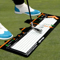 Black neoprene golf swing training pad for stance and posture correction on grass.