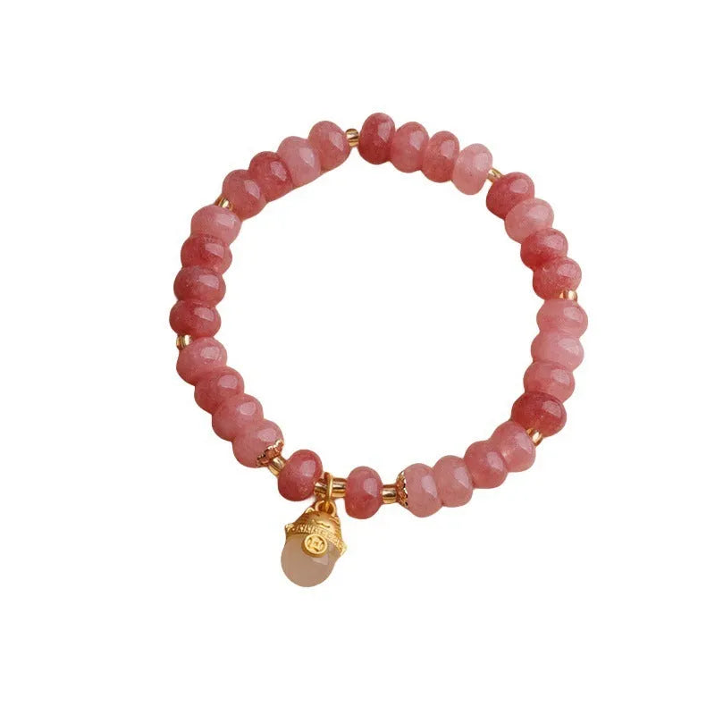 Women's lucky cat bracelet made from strung strawberry quartz or grey jade stones with zodiac charms.
