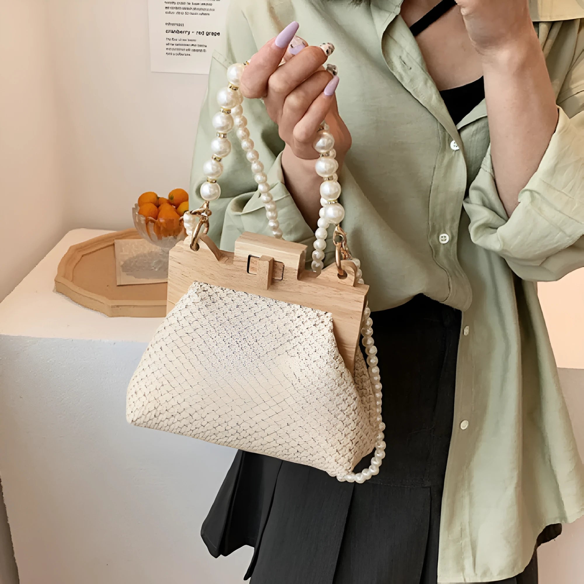 Women's woven straw shoulder bag with pearl chain strap showing interior organisation compartments